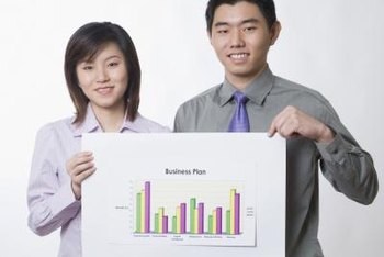 Two people holding a business plan graph